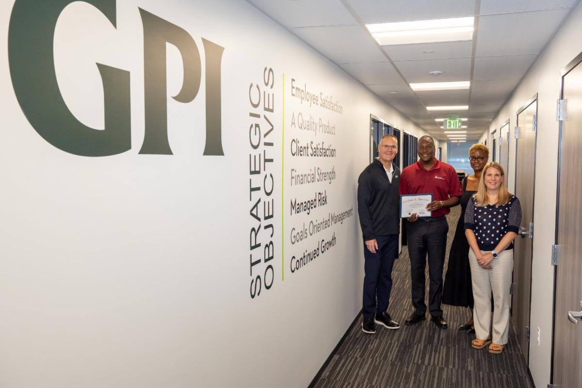County Executive Calvin Ball posed for a photo inside GPI Greenman-Pedersen, Inc. - Metro DC's office with two members of the company and Howard County Economic Development Authority CEO Jennifer Jones.