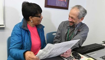A photo of a person receiving tax prep assistance from an AARP Foundation Tax-Aide volunteer .