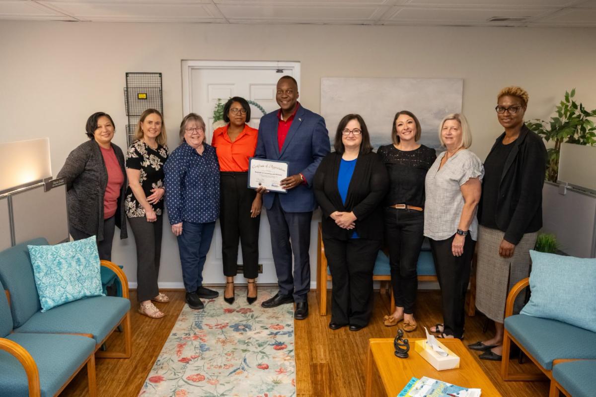 County Executive Calvin Ball posed for a photo inside Restorative Counseling & Wellness Center with Co-Founders Nicole DeChirico and Dionne Jiminez and staff members and Howard County Economic Development Authority CEO Jennifer Jones.