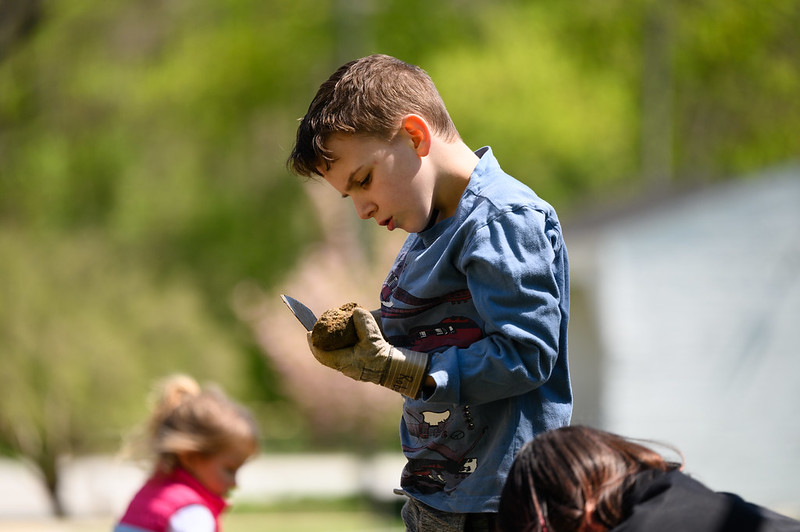 A photo of a young participant examining their find at Recreation & Parks' annual Archaeology Fest.