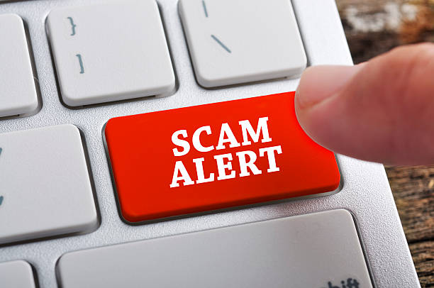 A photo of a computer keyboard with one red key reading Scam Alert.