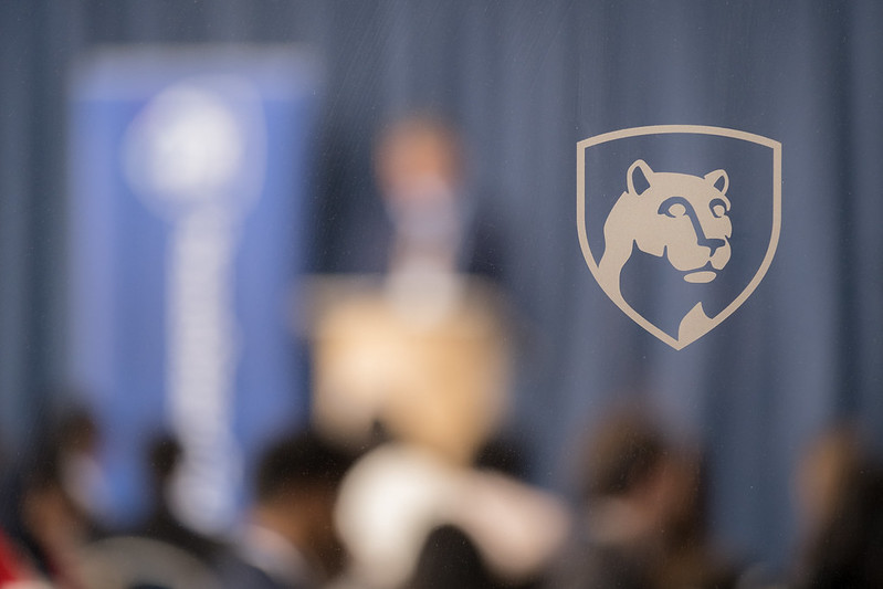 The Penn State shield on a frosted glass background