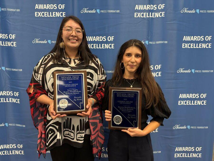 Two women holding award plaques from the Nevada Press Association.