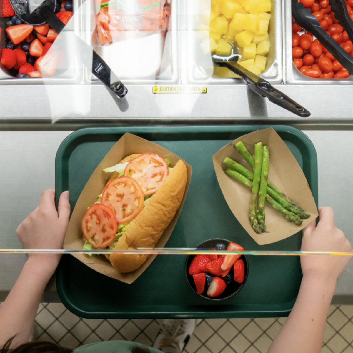 A student chooses Michigan fruits and vegetables for a school lunch.