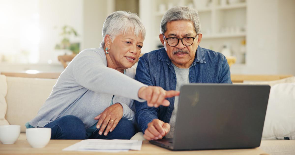 two people sitting indoors looking at computer