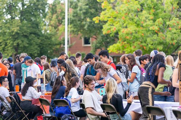 crowd of students around tables at the involvement fair