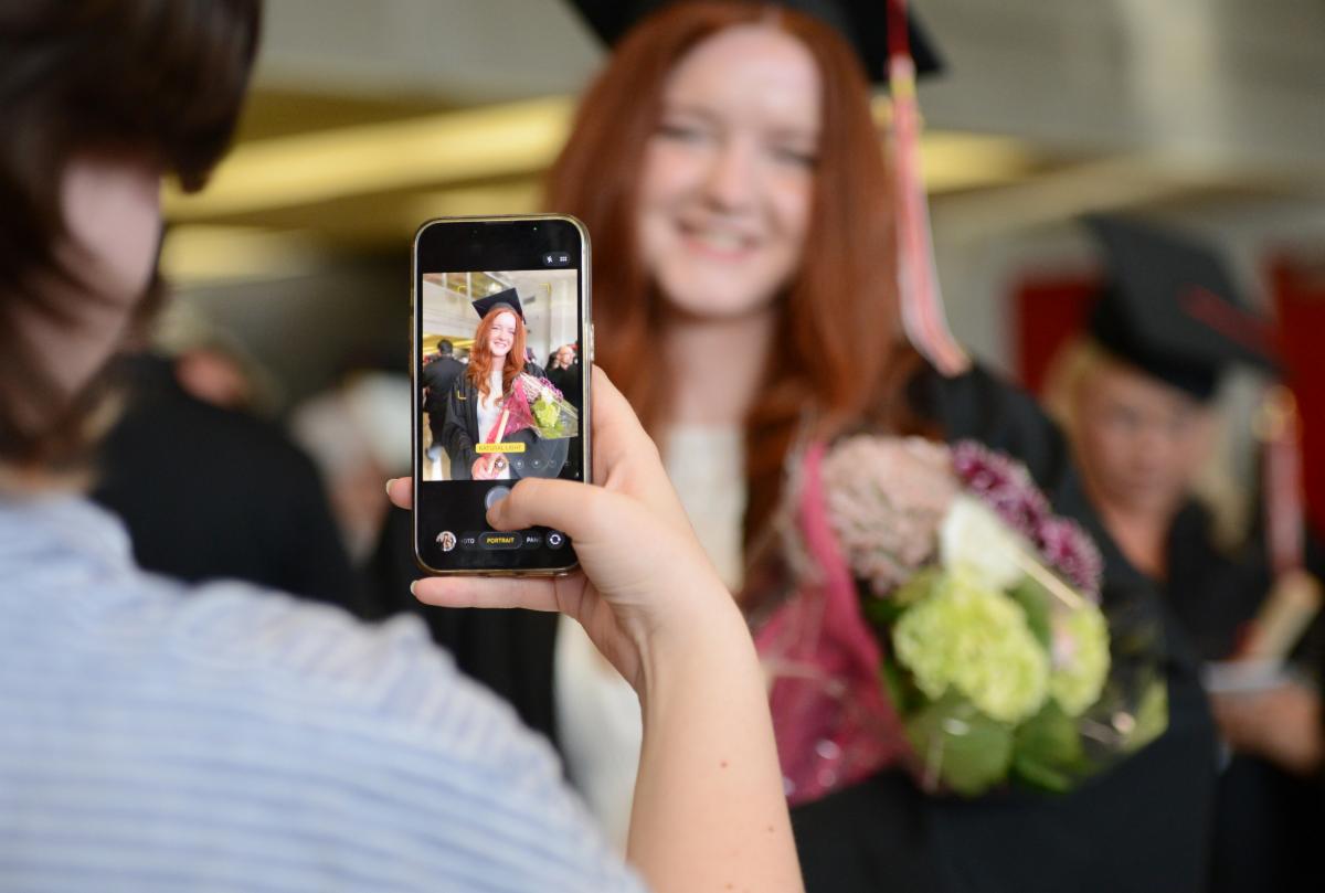 Saunders graduate getting their photo taken by a parent