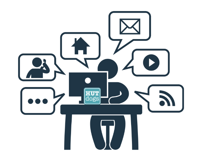 a stick figure seated at a table with a computer and multiple icons around his head