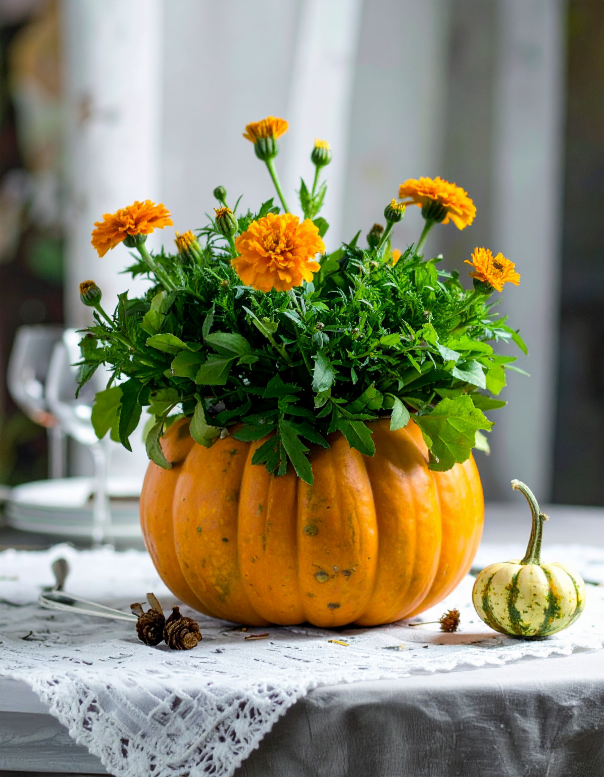 orange pumpkin centerpiece with orange marigold flowers inside