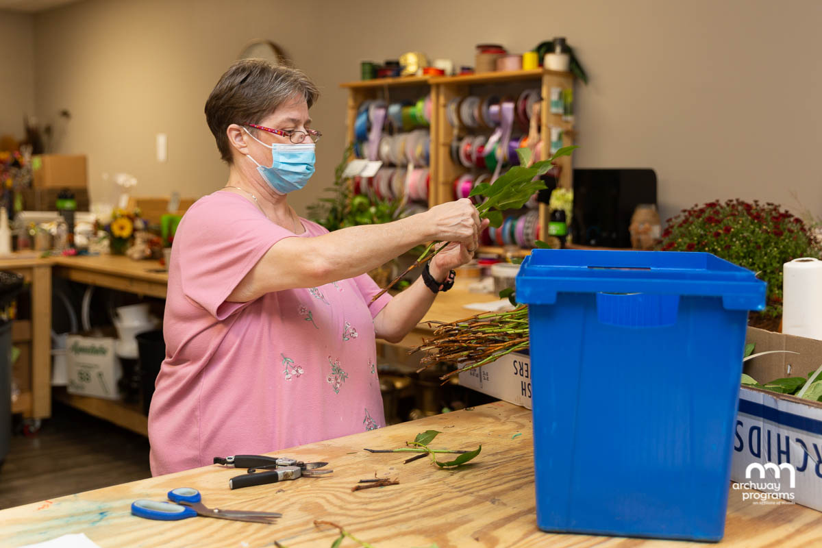 Carrisa trims greenery for a floral arrangement