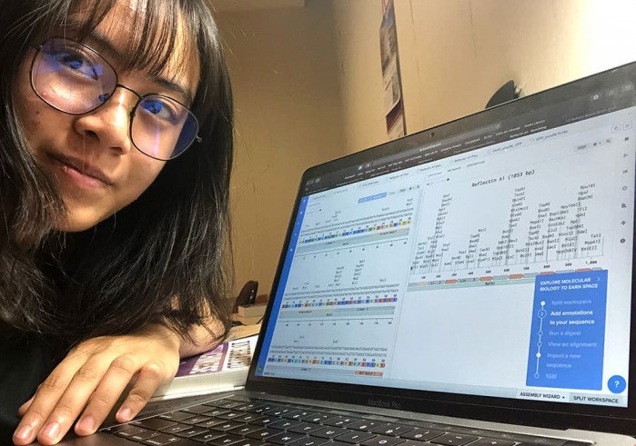  Anh Nguyen '23 with their research project displayed on a laptop