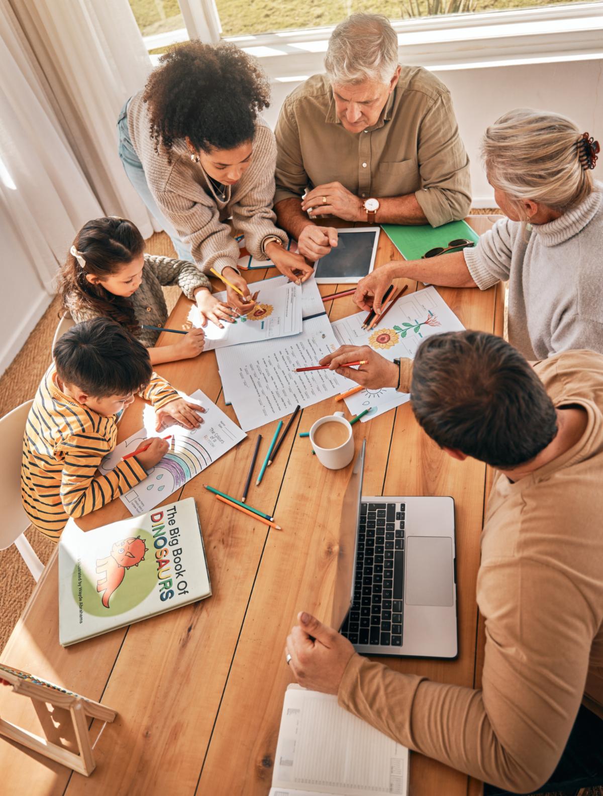 Family home kids and homework with learning grandparents and parents with tech in top view. Mother father and children with laptop tablet and paperwork in busy house with help reading or study