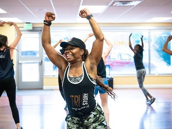 A group of people is arranged in a line for a fitness class.