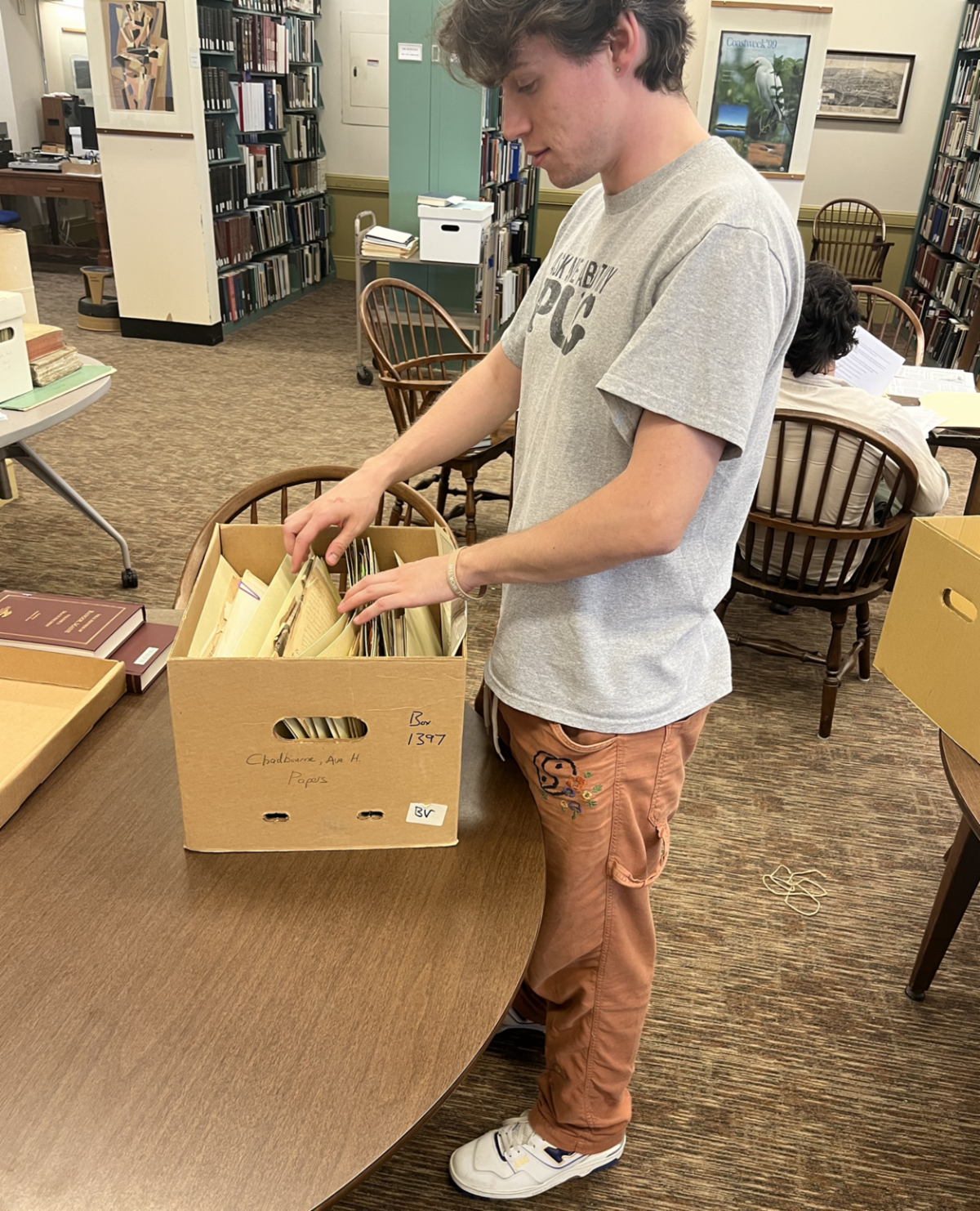 Student worker Tom Pinette in Special Collections and Projects