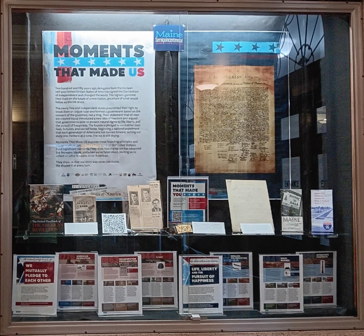 Photo of a display case containing a number of printed and archival materials.