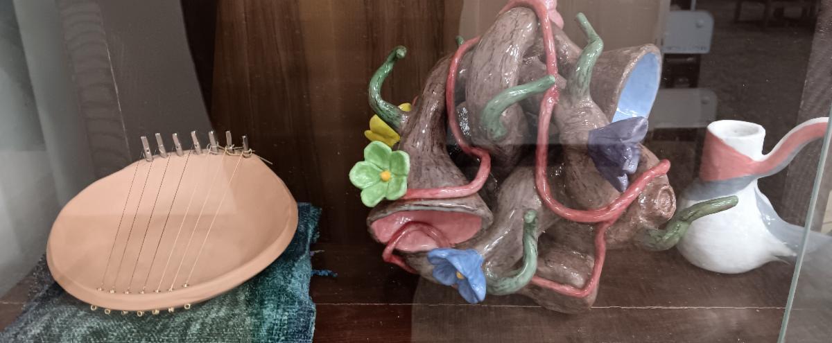 Close up photo of a ceramic bowl harp, a fanciful object that whistles when the wind blows through it, and part of a Peruvian whistling vessel.