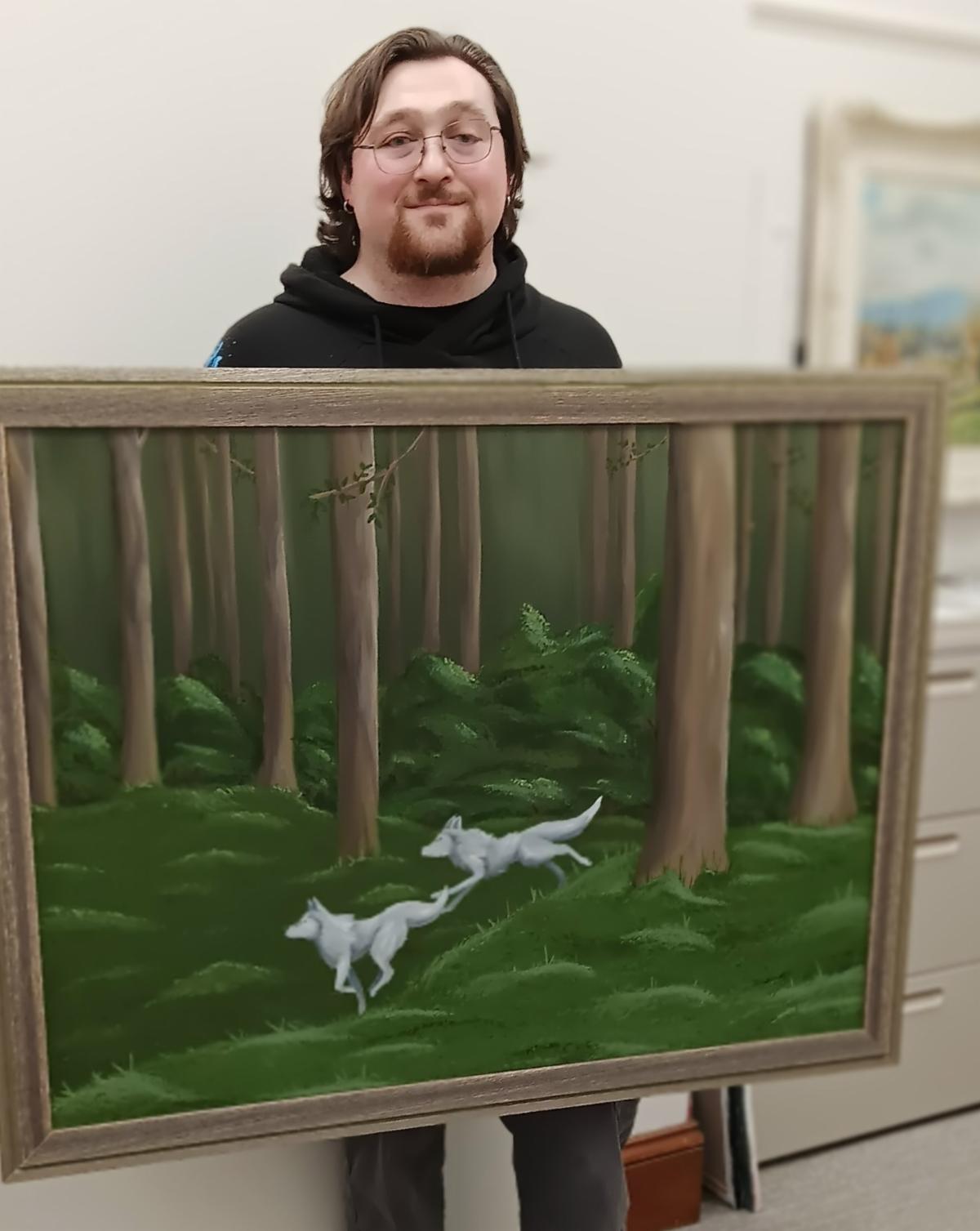 Photo of Max Chapman and his painting of two white wolves running through a forest