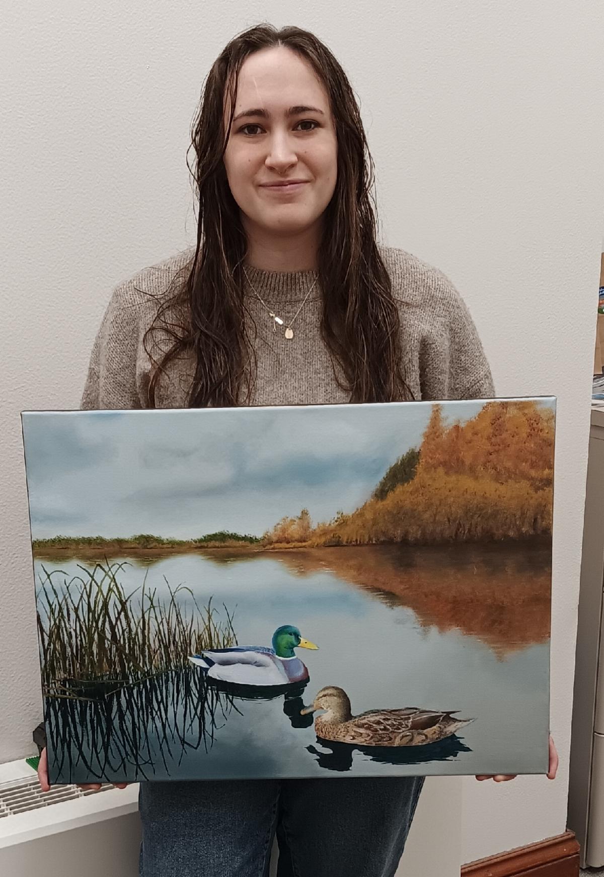 Photo of Liz Cambron with her painting of a pair of mallards