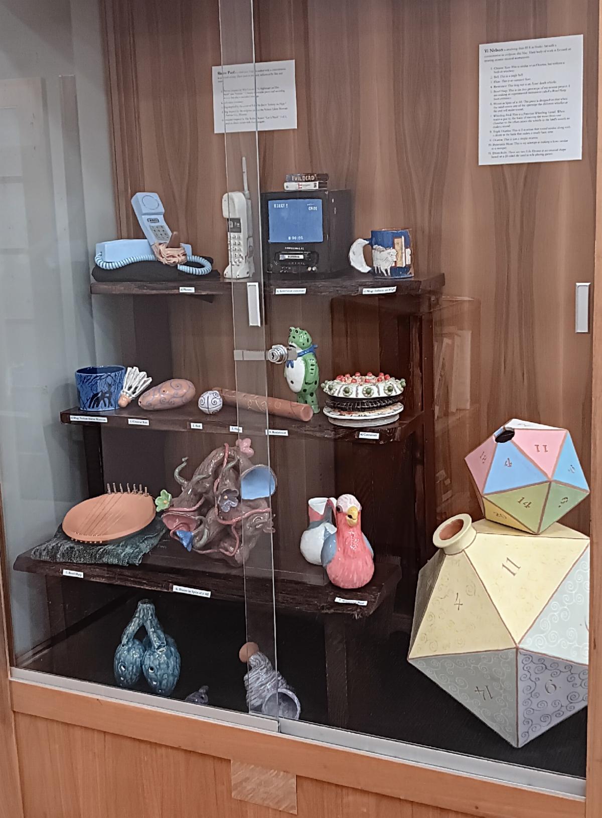 Photo of a display cabinet containing a number of colorful ceramic objects.