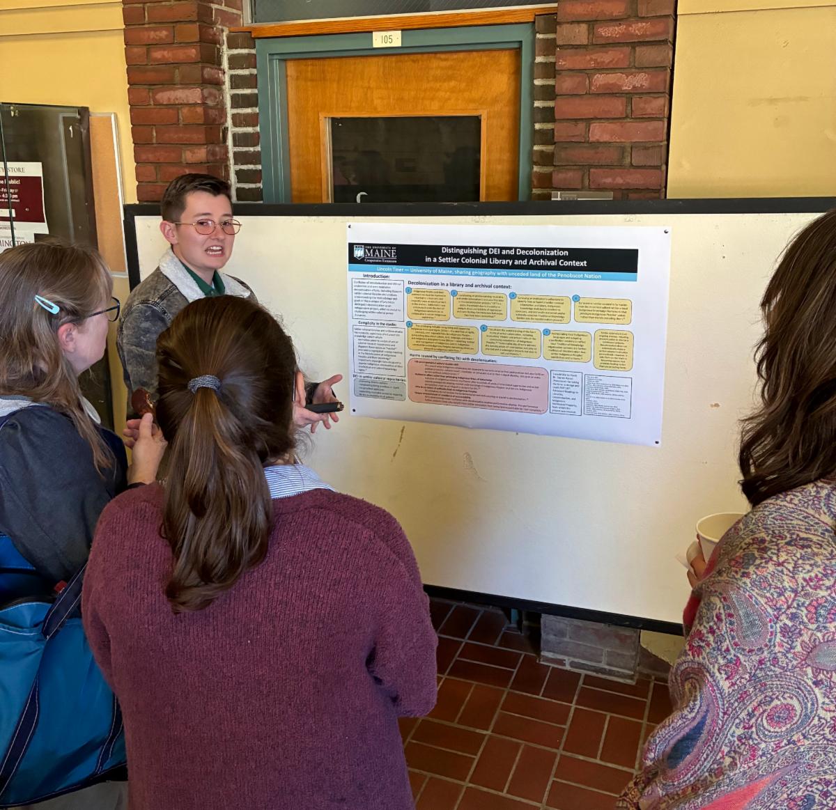 Photo of Lincoln Tiner showing his poster to event attendees.