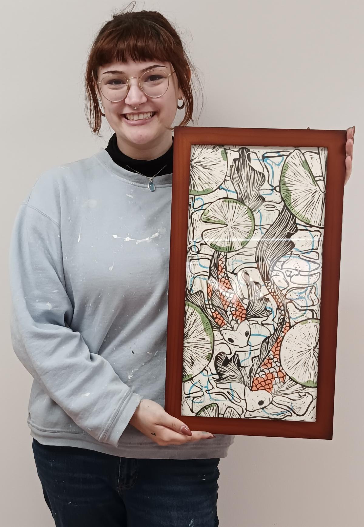 Photo of Rosemary Lavin with her woodcut print Downstream depicting goldfish