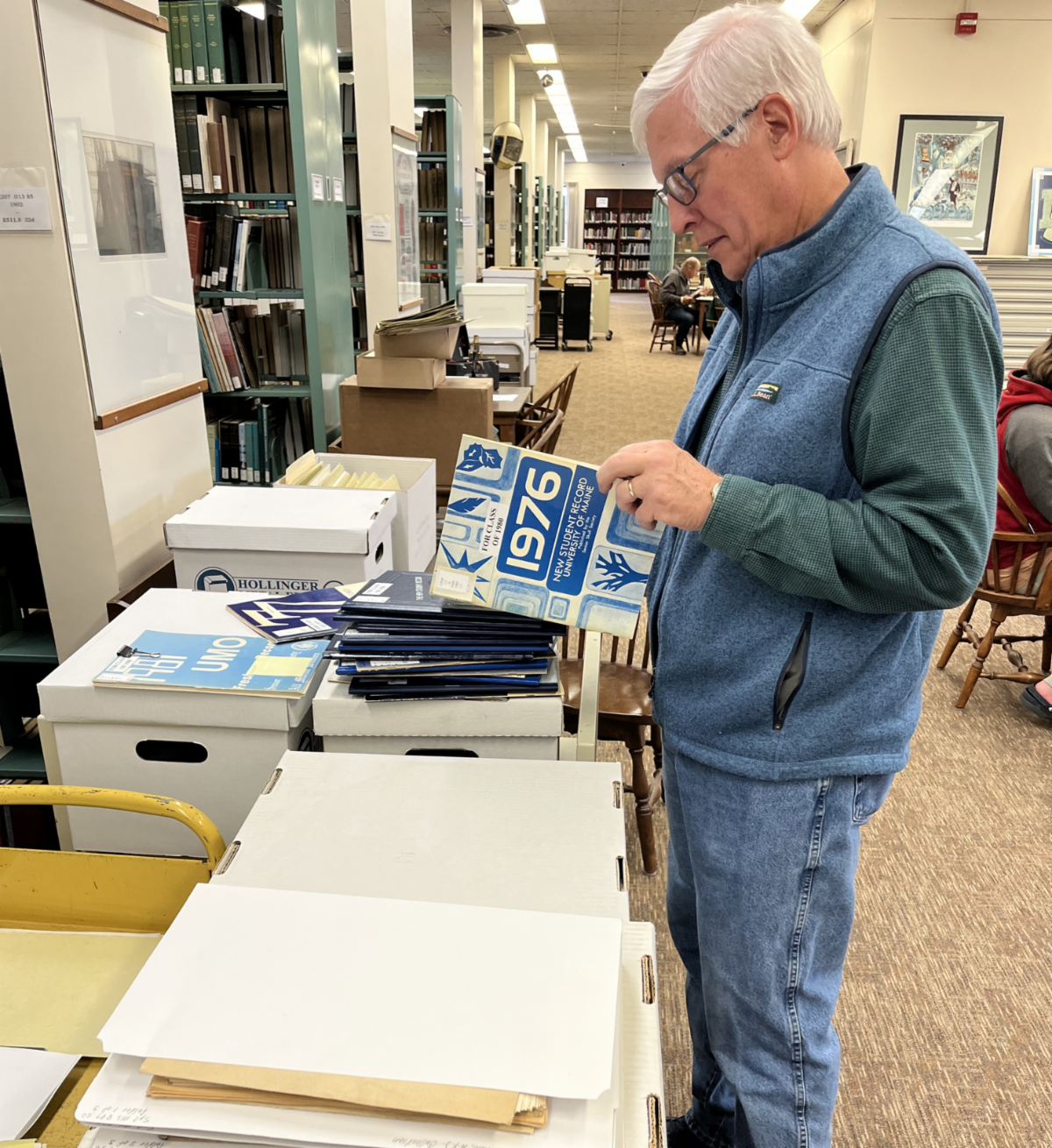 Photo of a man looking at a 1976 yearbook