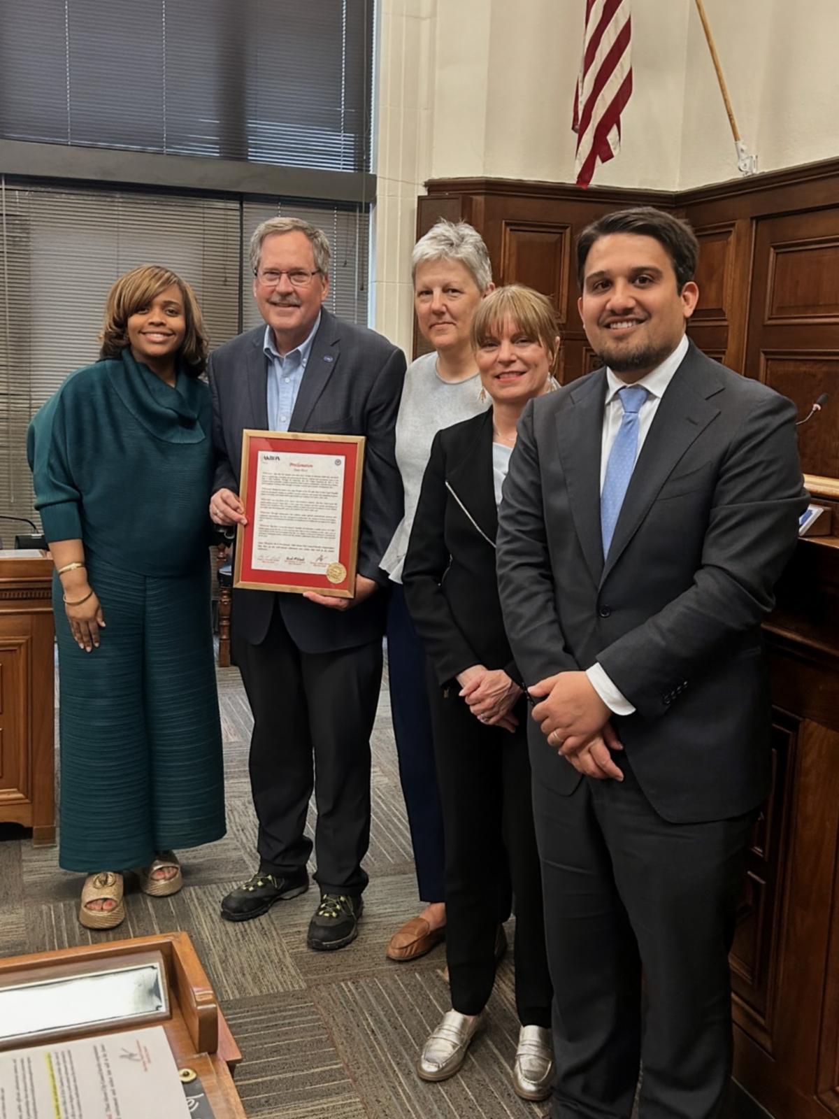President Sommerville, Tina Boyes, and Mayor Malik presenting a proclamation to Dan Rice