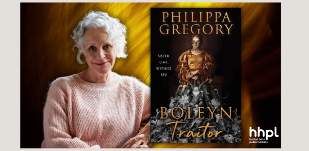 An older woman with short curly gray hair wearing a pink sweater sits smiling beside the cover of her book titled Boleyn Traitor by Philippa Gregory The book cover features a regal woman in Tudor-era clothing with the tagline Sister Liar Witness Spy
