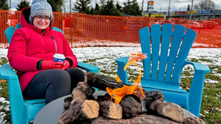 Resident enjoying a treat at fire pit popup