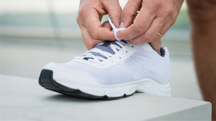 Person tying up an athletic shoe