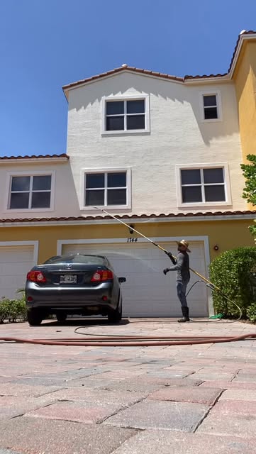 Our crew pressure washing the outside of a two-story home