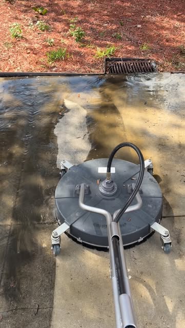 Concrete being cleaned with a surface cleaner, leaving a clean path through the grime