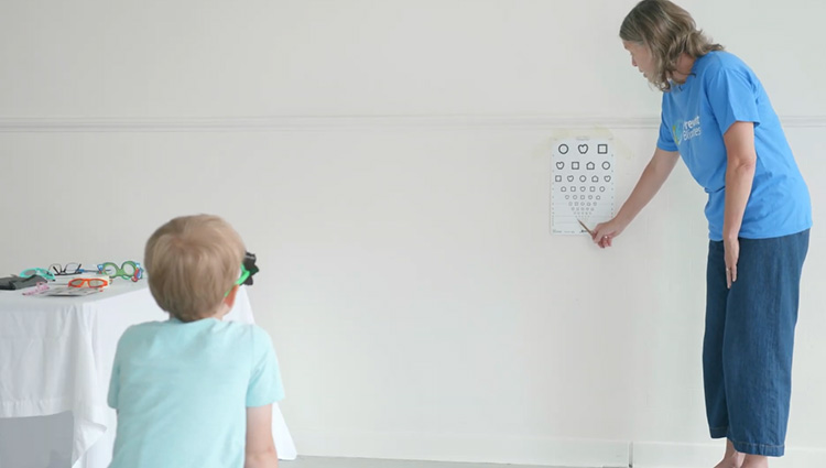 Prevent Blindness staff demonstrates children's vision screening technique