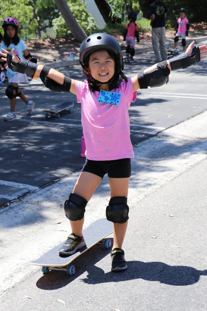 A triumphant Girl Scout skateboarding
