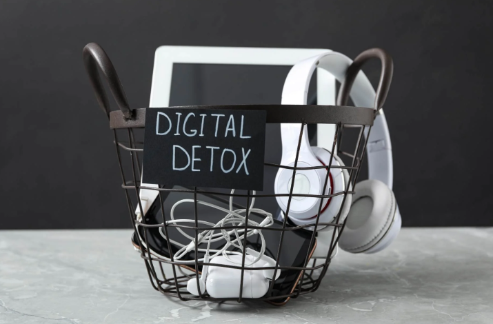 image of a basket with various digital devices, like cell phone, head phones, ear buds, and tablets