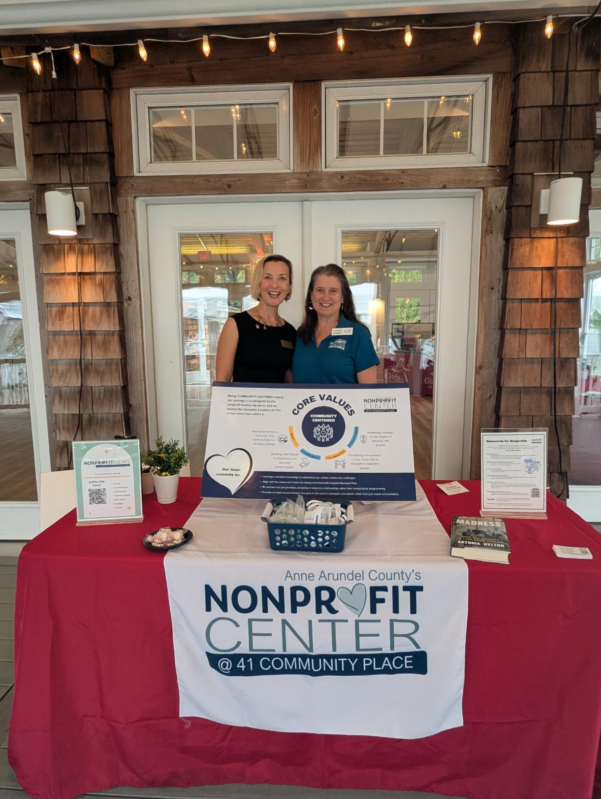 two women standing in front of a display table for the NPC