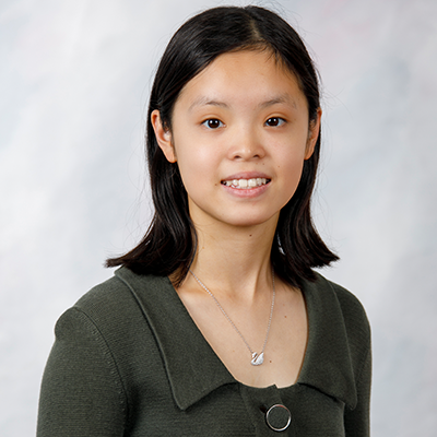 Teen girl with shoulder length black hair waering gray top