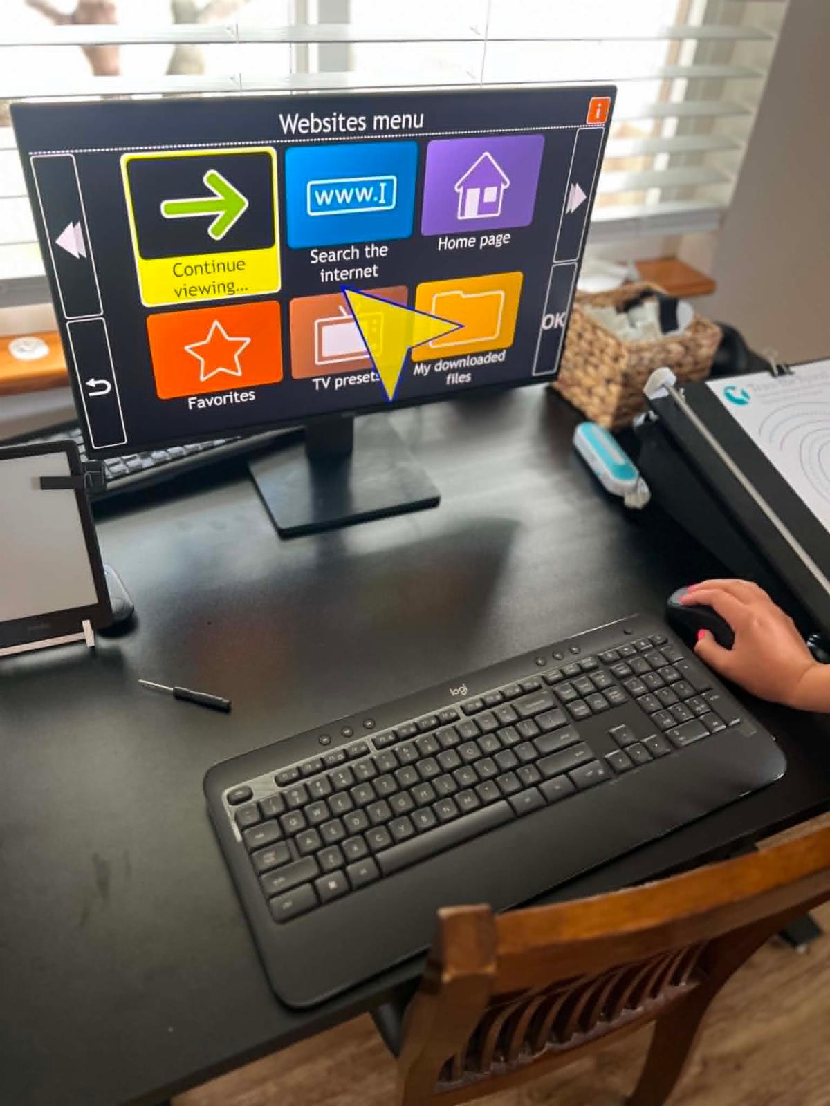 Person using an accessible computer workstation with a simplified visual navigation interface designed for independent technology access.