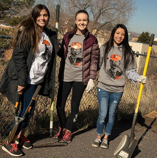 students working with shovels and gloves during a day of service