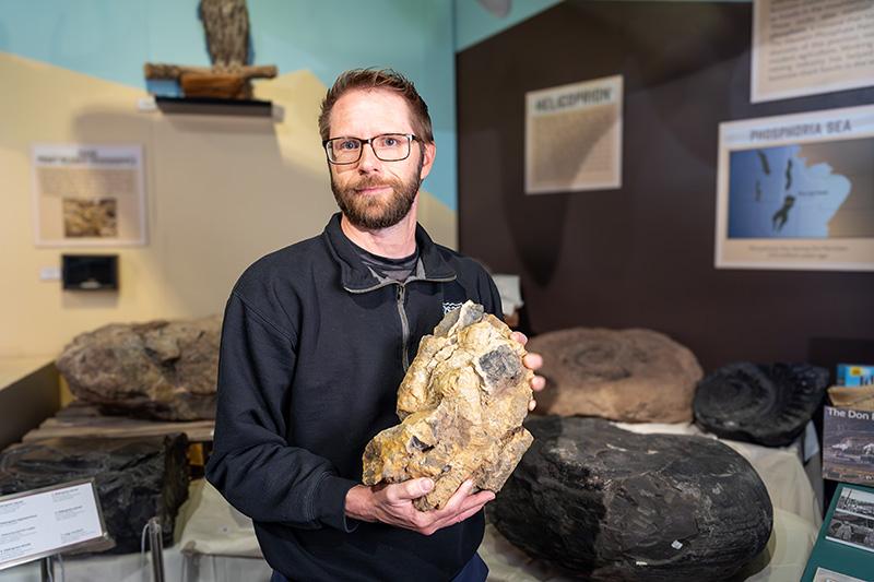 Leif Tapanila director of the Idaho Museum of Natural History and professor of geosciences at Idaho State University poses for a photo holding a piece of chert containing spicules
