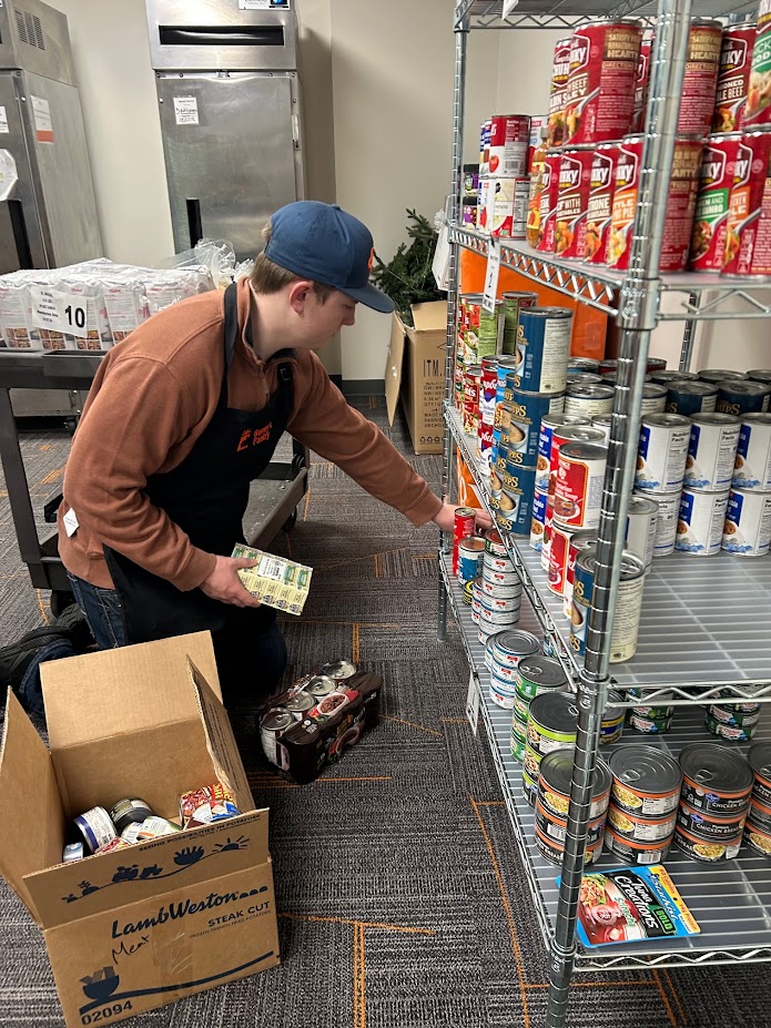 A student stocking shelves at Benny's Pantry