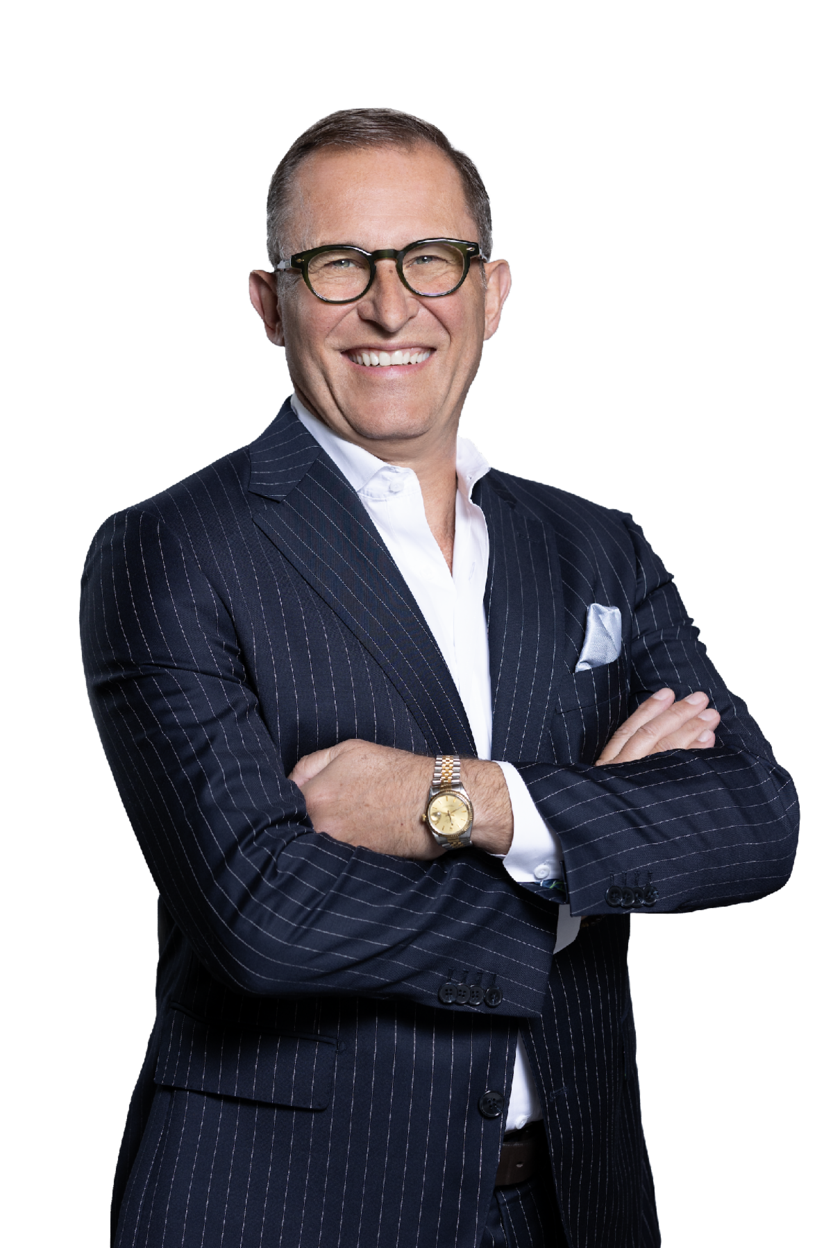Smiling middle aged man wearing glasses and a navy pinstripe suit with a white shirt, arms crossed, posed against a transparent background