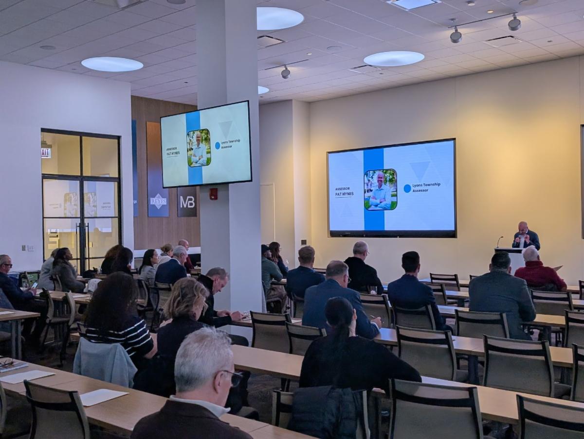 People seated in a conference room listening to a speaker