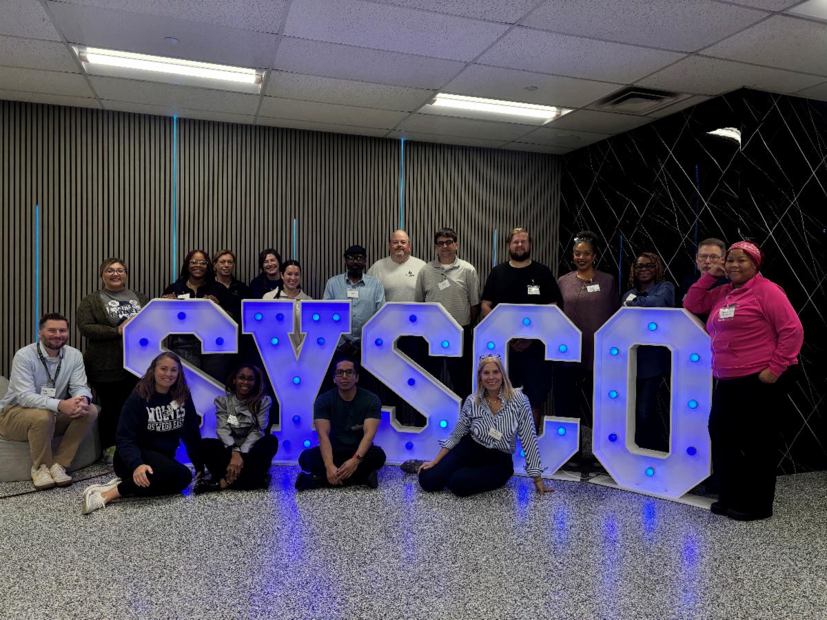 People posing with Sysco logo