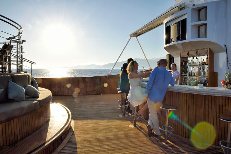 Couple at bar on deck of M-Y CHRISTINA O