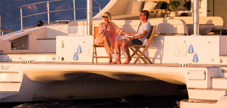 Couple enjoys sunset on the aft deck of sailing catamaran OMBRE BLU 3 in the Mediterranean
