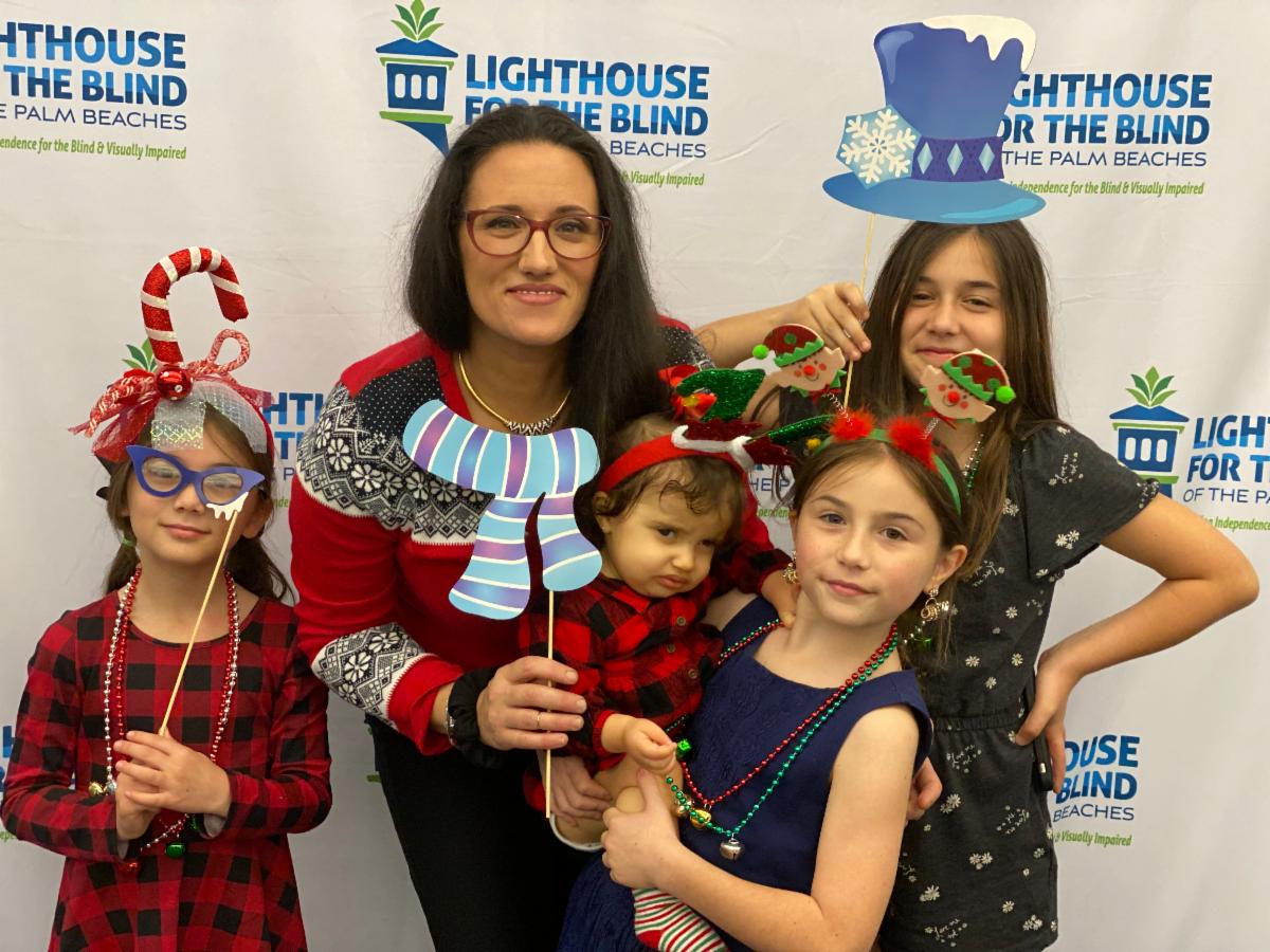 Mom, baby and three young girls posing with Christmas photo props