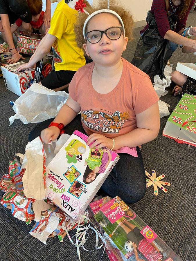 Young girl opening her presents