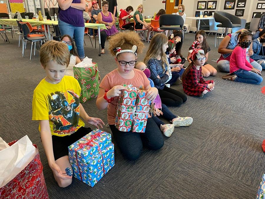 Kids sitting around tree getting ready to open presents