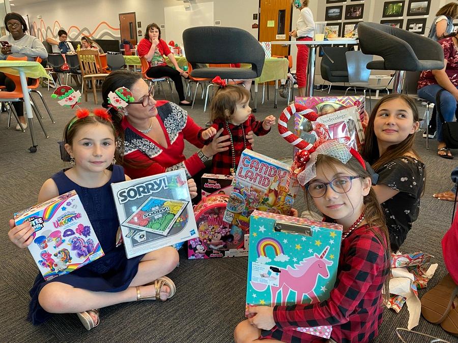 Three girls holding up their gifts
